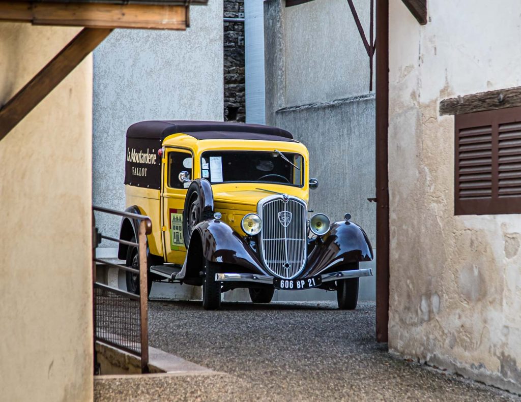 Ein Lieferfahrzeug aus vergangener Zeit steht im Hof der Moutarderie Edmond Fallot / © Foto: Georg Berg