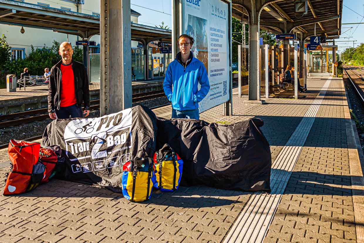 Georg Berg mit Sohn Julius auf dem Bahnsteig. Das Gepäck besteht aus Satteltaschen und verpackten Fahrrädern / © Foto: Georg Berg