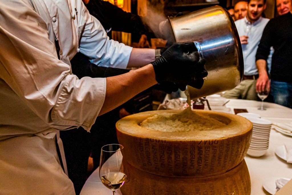 Ein ausgehöhlter Parmesanlaib wird mit Risotto gefüllt / © Foto: Georg Berg