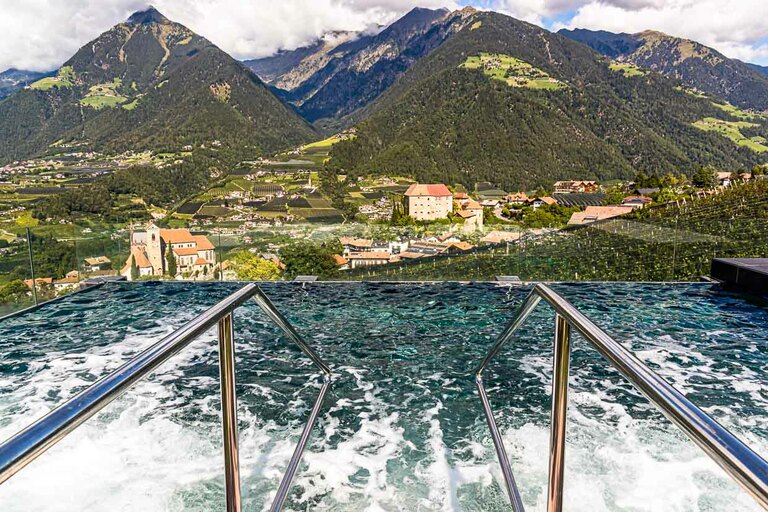 Piscina termal en la zona de bienestar de la azotea del Hotel Hohenwart con una amplia vista del paisaje que rodea Schenna, en Tirol del Sur / © Foto: Georg Berg