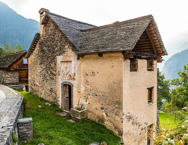 En Cerentino, puede alojarse en la histórica casa patricia Cà Vegia, lujosamente renovada, con muebles originales de siglos de antigüedad, pero sin electricidad. El lavabo está delante de la puerta de entrada, Circolo della Rovana, Suiza / © Foto: Georg Berg