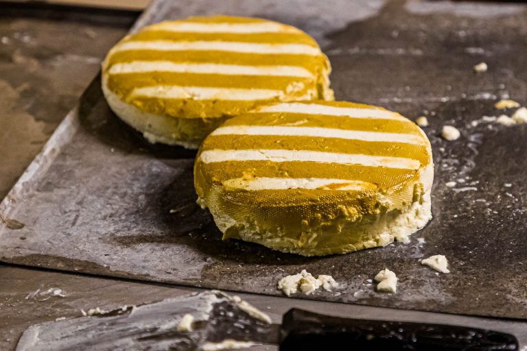 Tras 20 segundos en el denso humo de la paja, las ruedas de queso quedan rayadas / © Foto: Georg Berg