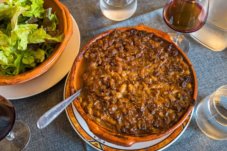El Chef Eric Rousselot prepara el famoso Cassoulet Imperial en la Hostellerie Etienne, empresa familiar desde 1956. La costra marrón forma parte de un buen cassoulet. Además, una simple ensalada y un vaso de vino - ¡c'est tout - c'est bien! / © Fotografía: Georg Berg